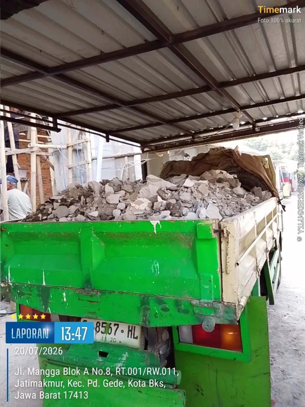 Truk hijau mengangkut puing beton dan sisa renovasi bangunan